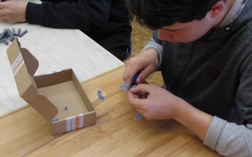 Starší žáci začišťují 3D výtisky trpasličích návěstidel.